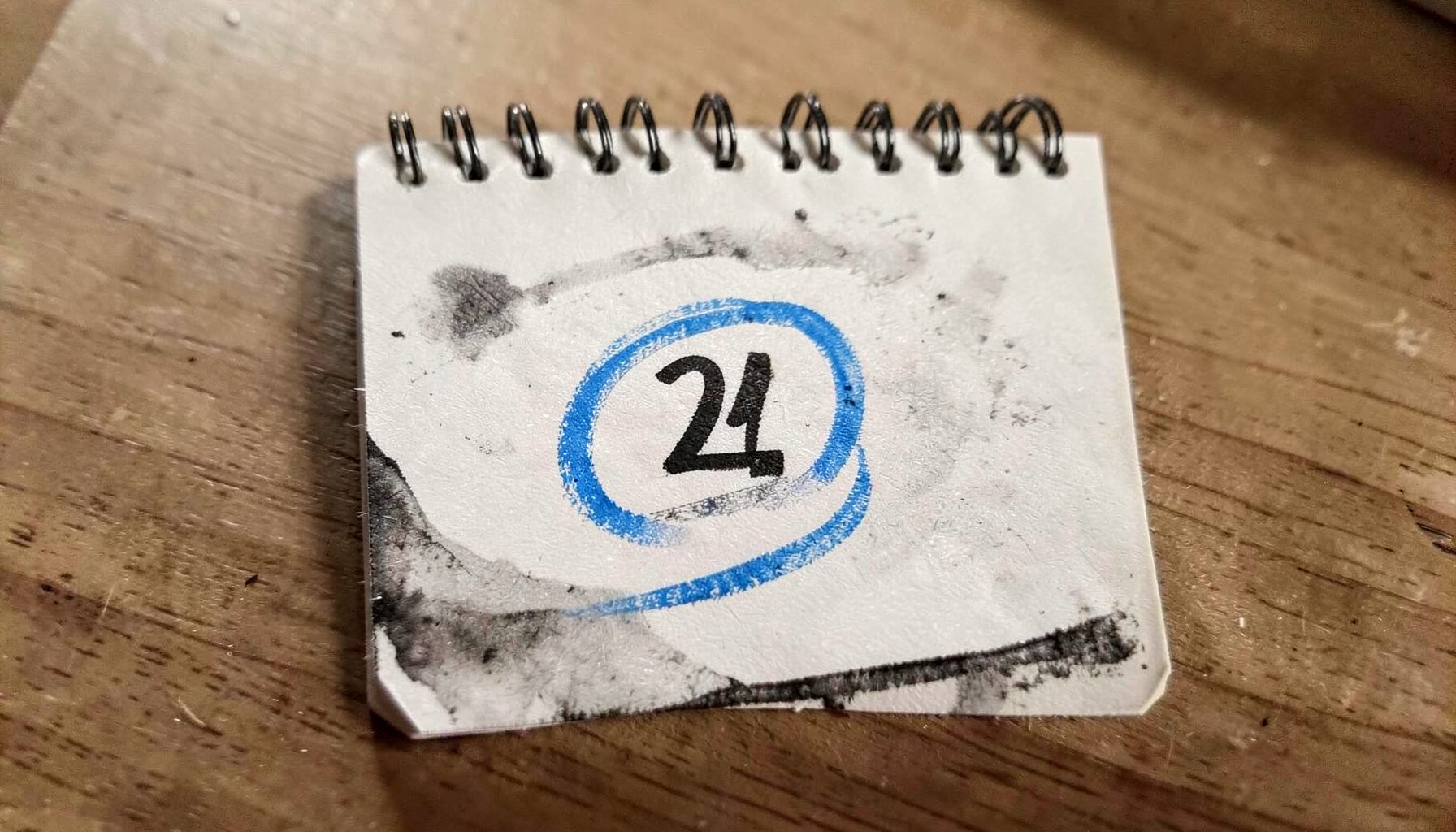 Ilustrasi arang tebal kalender meja dengan satu tanggal dilingkari, cahaya pagi lembut, suasana kontemplatif